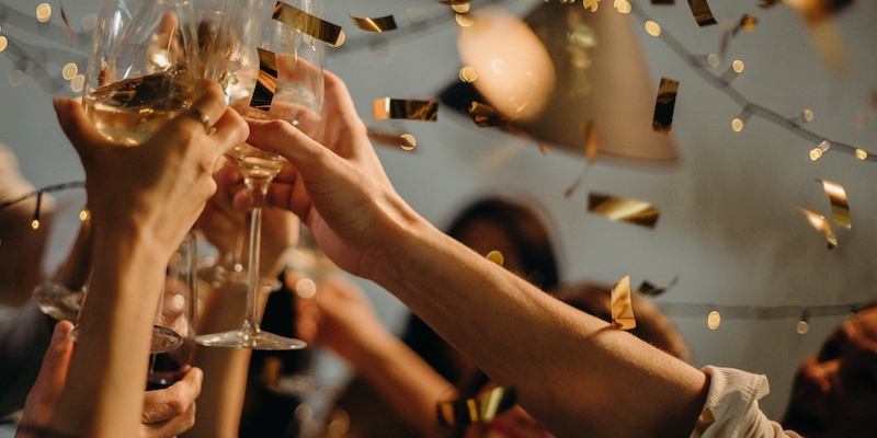 people celebrating holding up champagne glasses